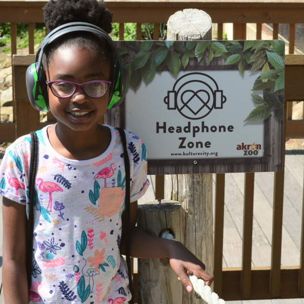 Girl with headphones near "Headphone Zone" sign