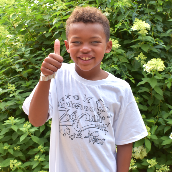 Boy in ZooCamp shirt giving a thumbs up