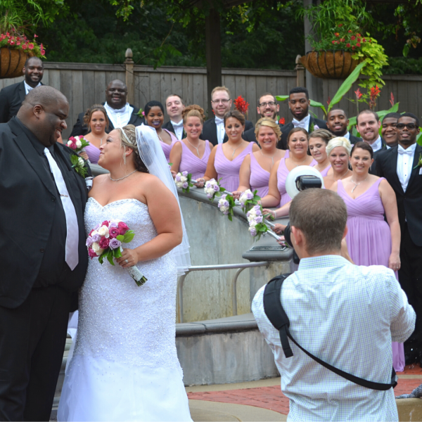 Photographer capturing photo of wedding party in zoo gardens