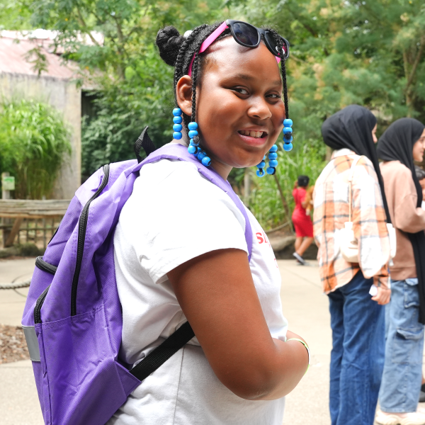 Girl wearing purple backpack at zoo event