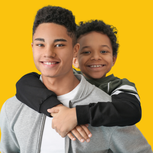 Young boy hugging older boy
